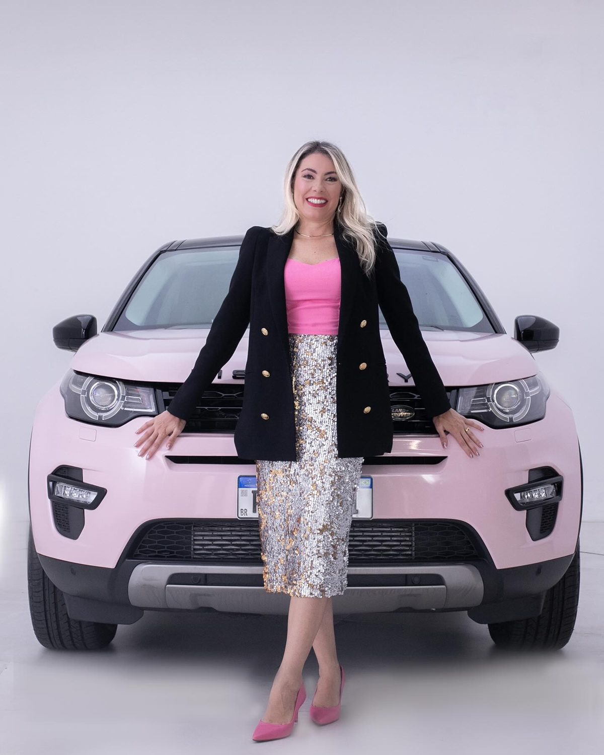 Helena em frente ao Land Rover Discovery rosa